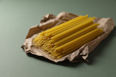 Photo of Many church wax candles on olive background