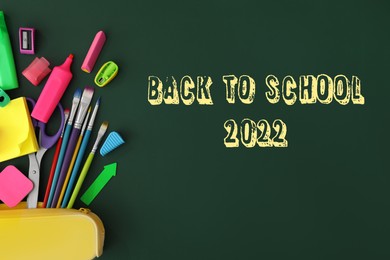 Back to school 2022. Flat lay composition with different stationery on green chalkboard