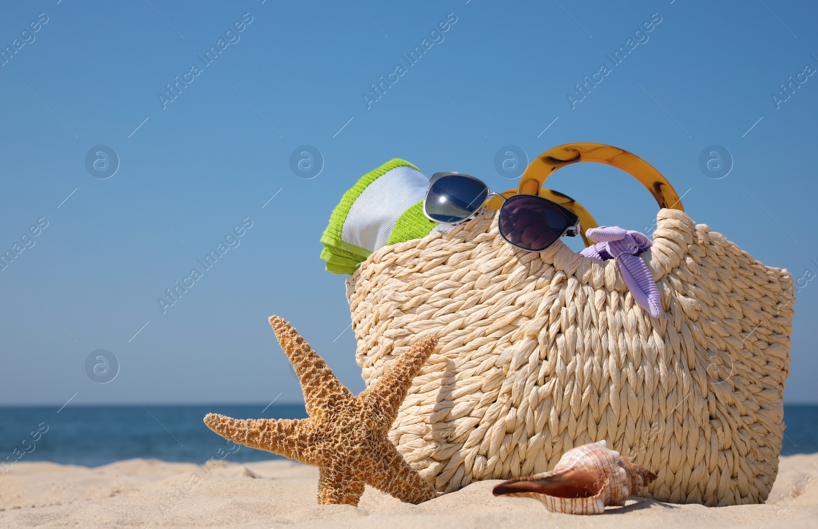 Photo of Bag with beach accessories on seaside. Space for text