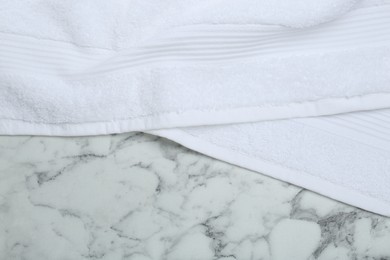 Photo of Terry towel on white marble table, top view. Space for text