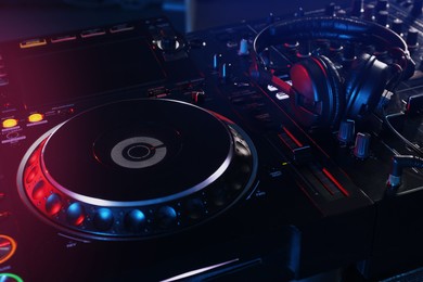 Photo of Closeup view of modern DJ controller with headphones