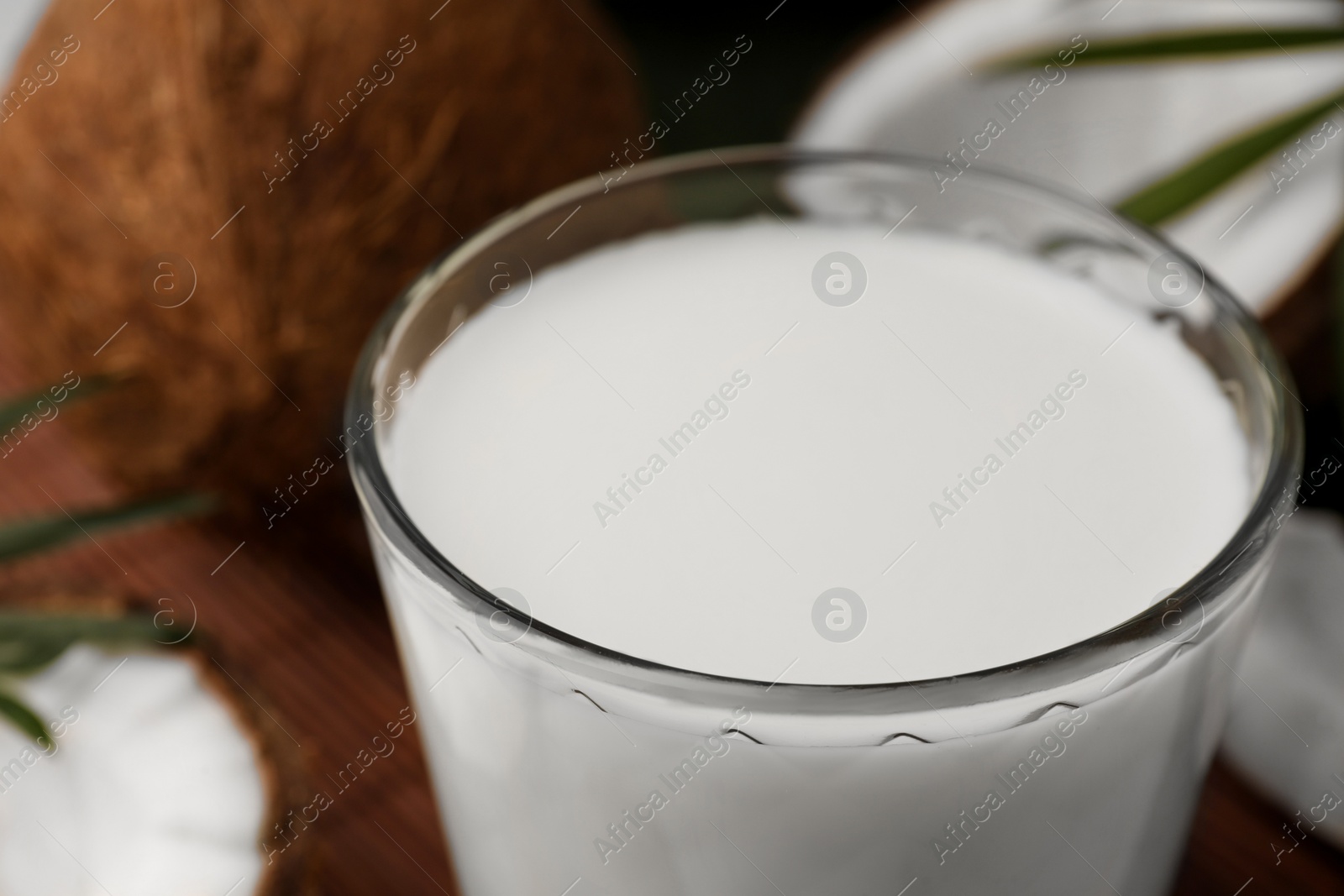 Photo of Glass of delicious coconut milk on table, closeup view