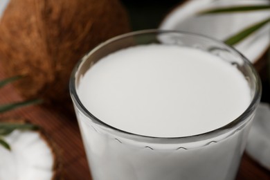 Glass of delicious coconut milk on table, closeup view