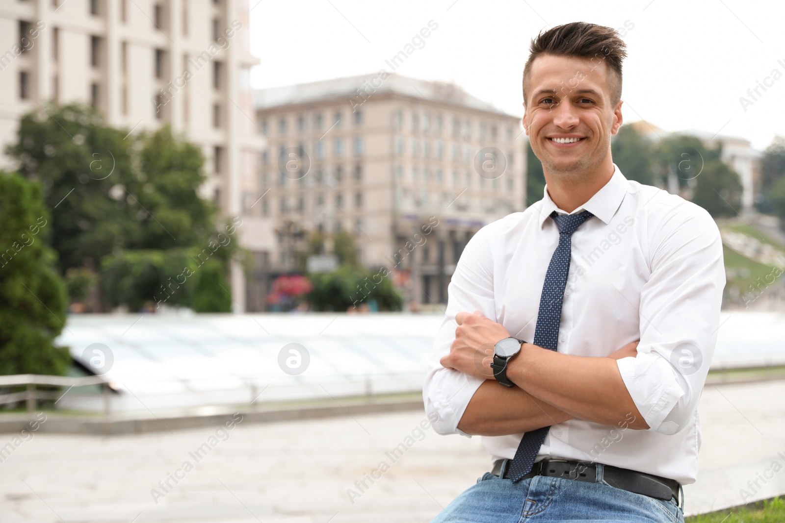 Photo of Portrait of handsome young man on city street. Space for text