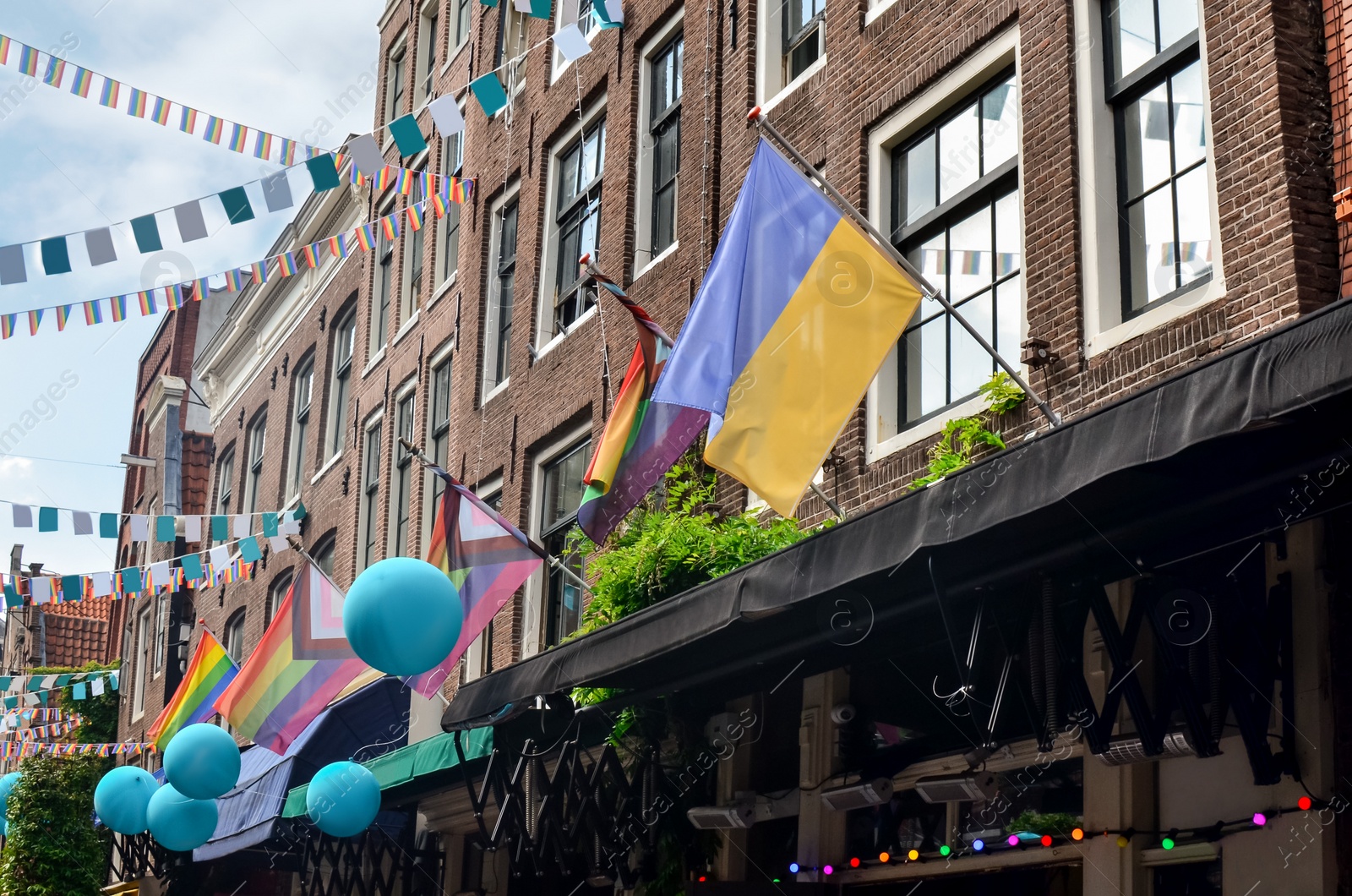 Photo of Picturesque view of city street with rainbow and Ukrainian flags