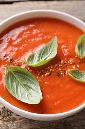 Photo of Delicious tomato soup with basil and spices on table, closeup