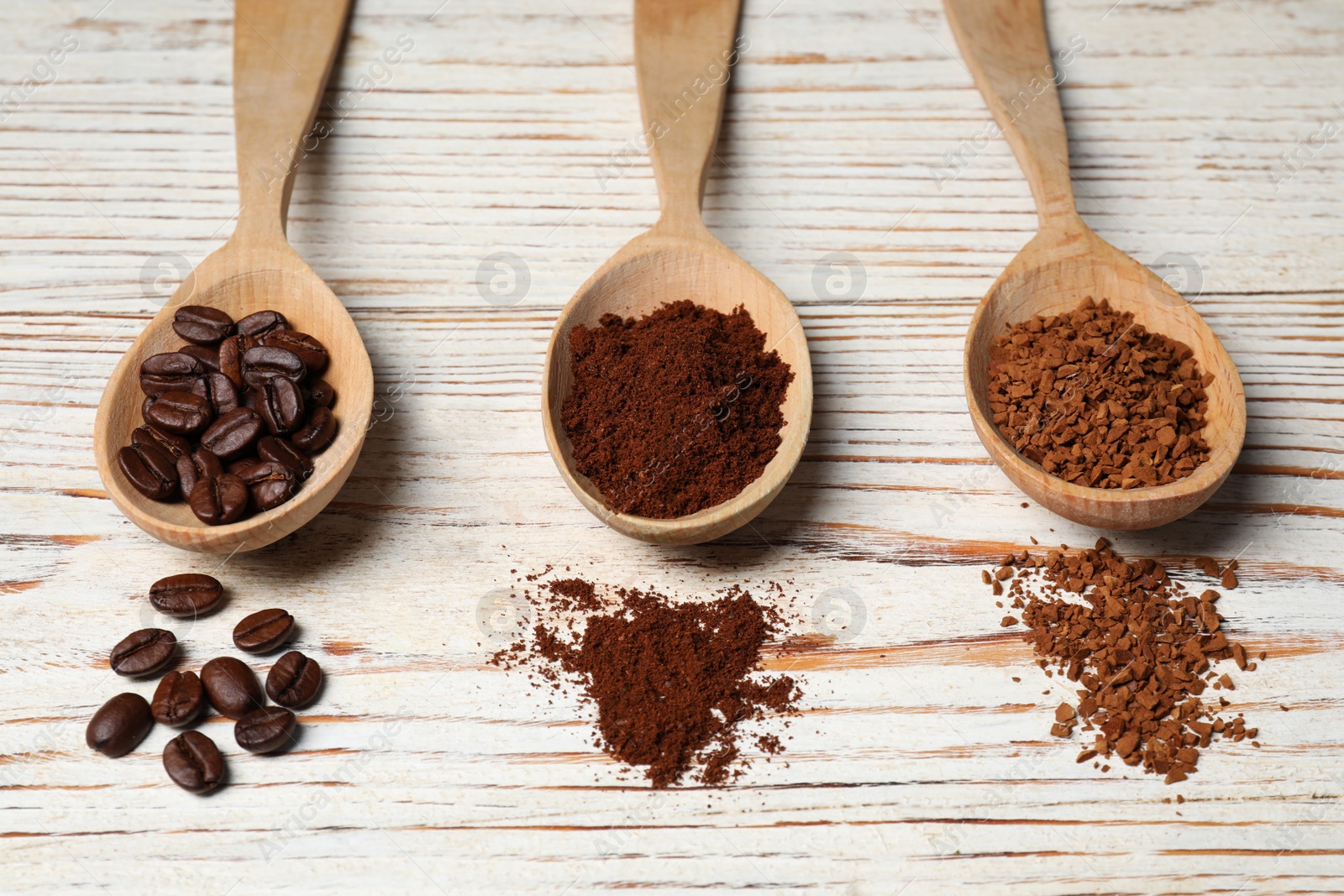 Photo of Instant, ground coffee and roasted beans on white wooden table