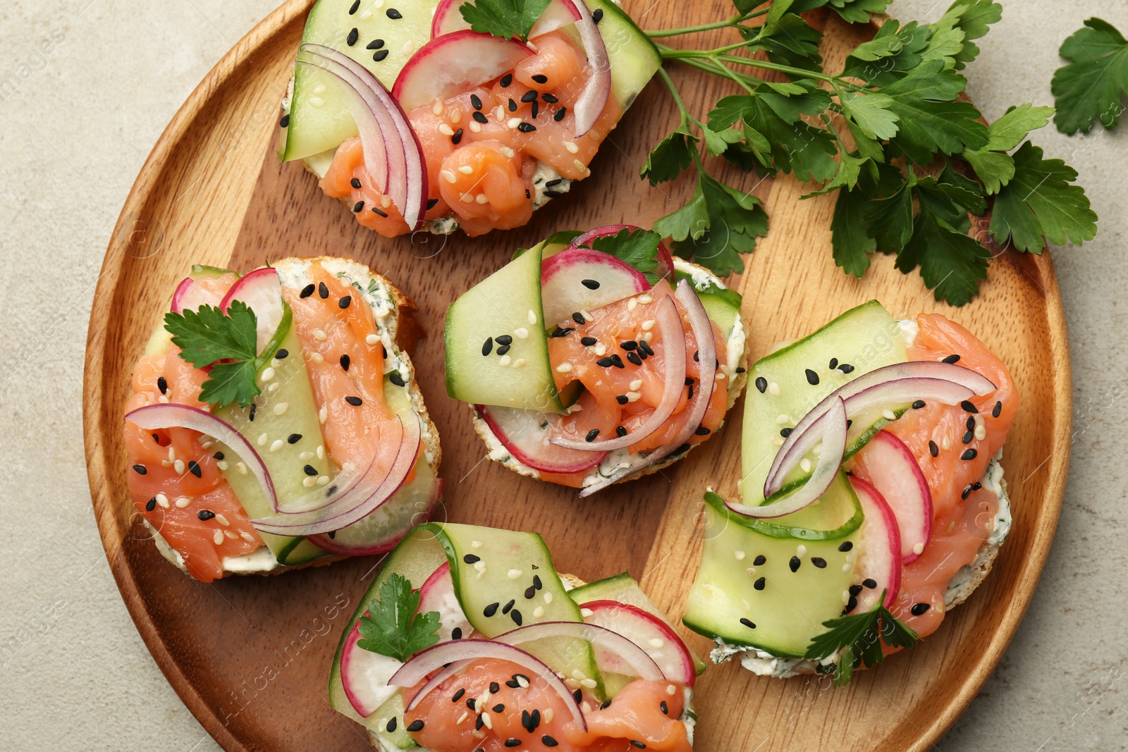 Photo of Tasty canapes with salmon served on light grey table, top view