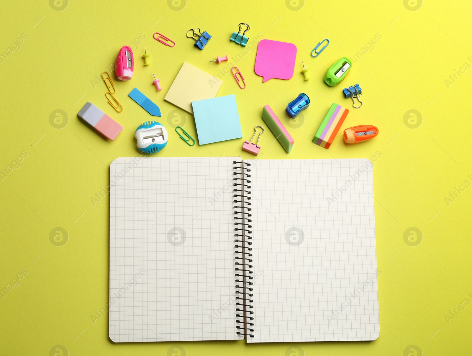 Photo of Blank notebook and school stationery on yellow background, flat lay with space for text. Back to school