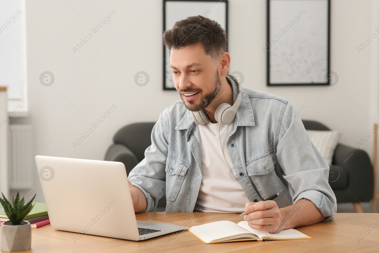 Photo of Online translation course. Happy man near laptop at home