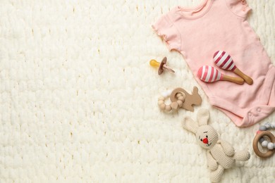 Photo of Different baby stuff on light knitted fabric, flat lay. Space for text
