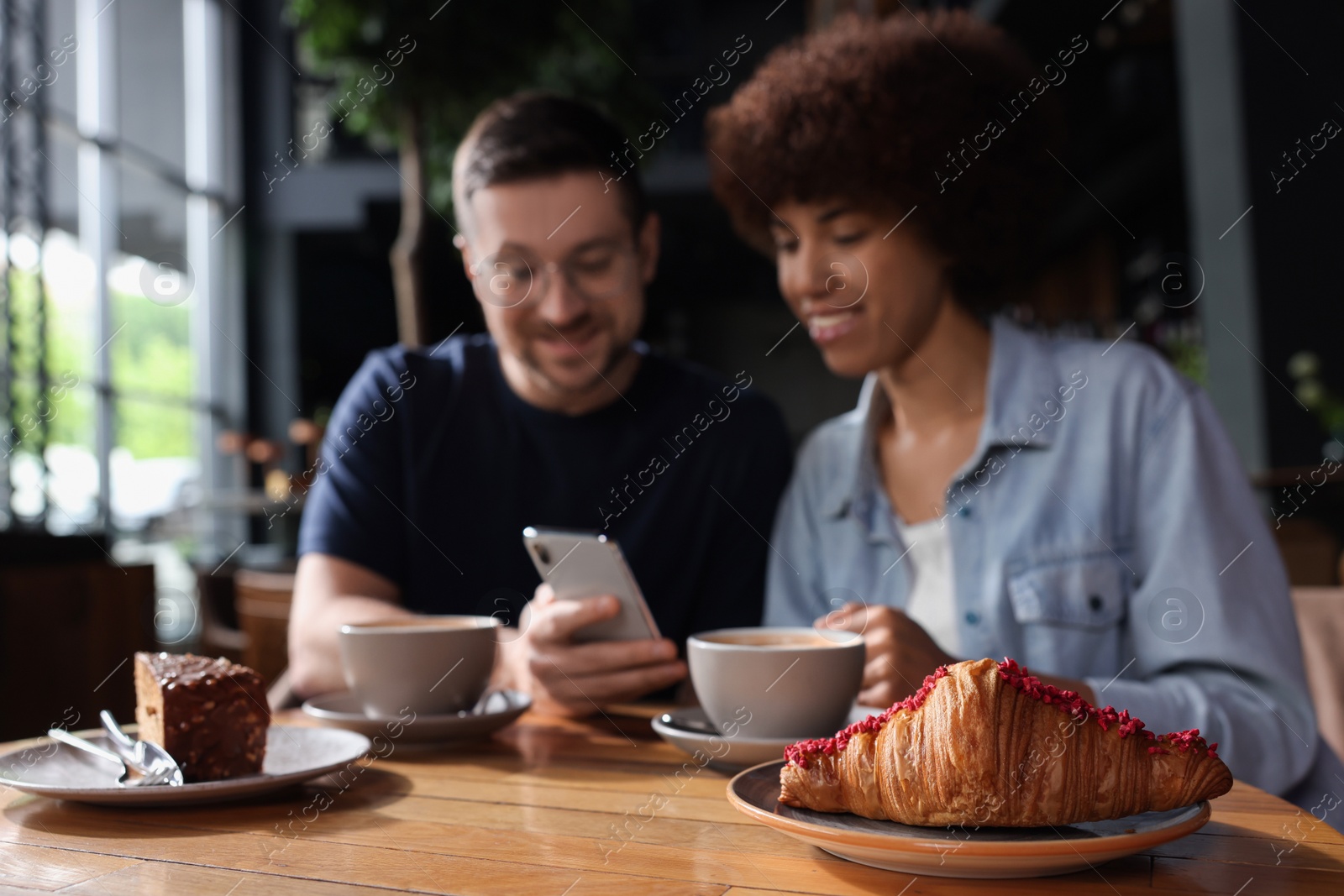 Photo of International dating. Lovely couple spending time together in cafe, selective focus