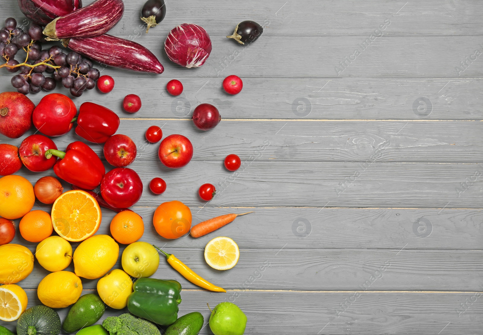 Photo of Rainbow composition with fresh vegetables and fruits on wooden background, flat lay