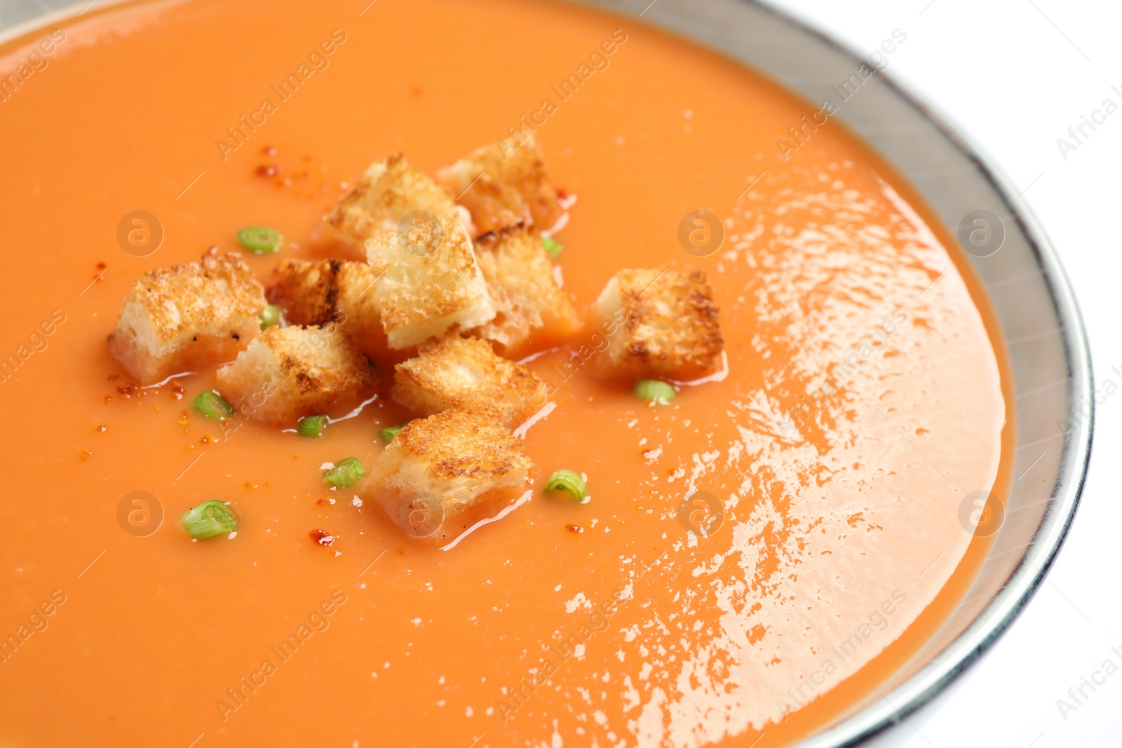 Photo of Tasty creamy pumpkin soup with croutons in bowl on white background, closeup