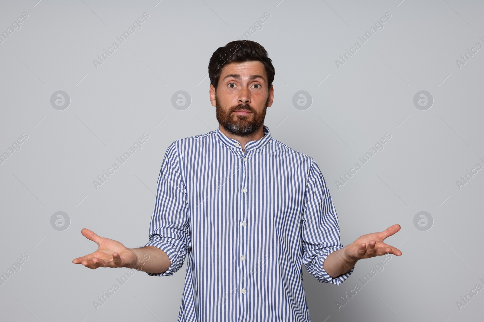 Photo of Bearded man throwing up hands on grey background