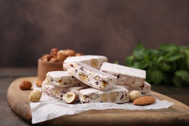 Photo of Pieces of delicious nutty nougat on board