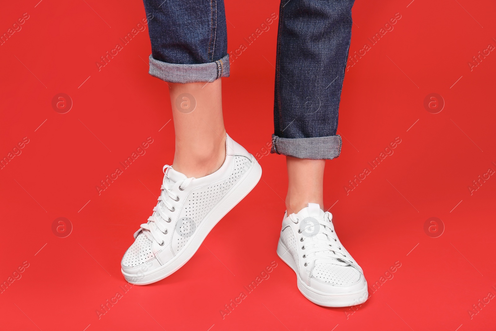 Photo of Woman in stylish sport shoes on color background