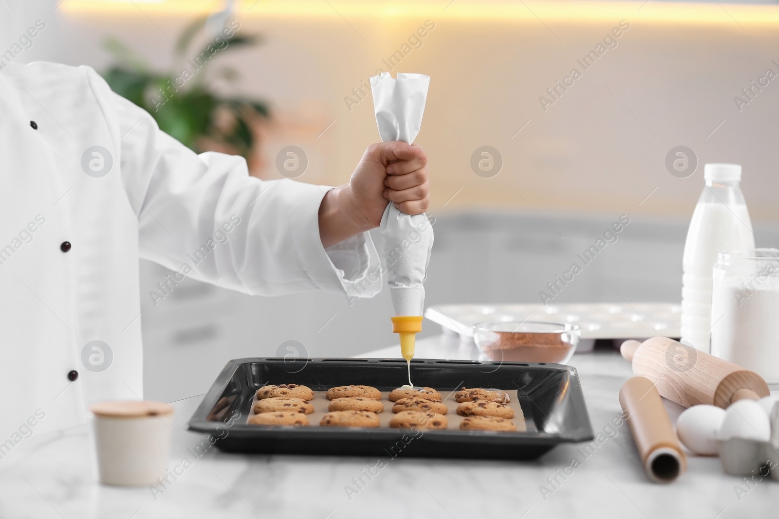 Photo of Female chef preparing biscuits at kitchen table, closeup. Cooking delicious food