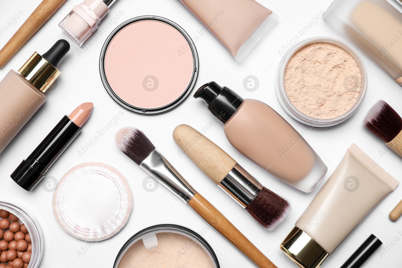 Photo of Face powders and other makeup products on white background, flat lay