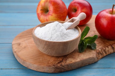 Photo of Sweet fructose powder, mint leaves and apples on light blue wooden table