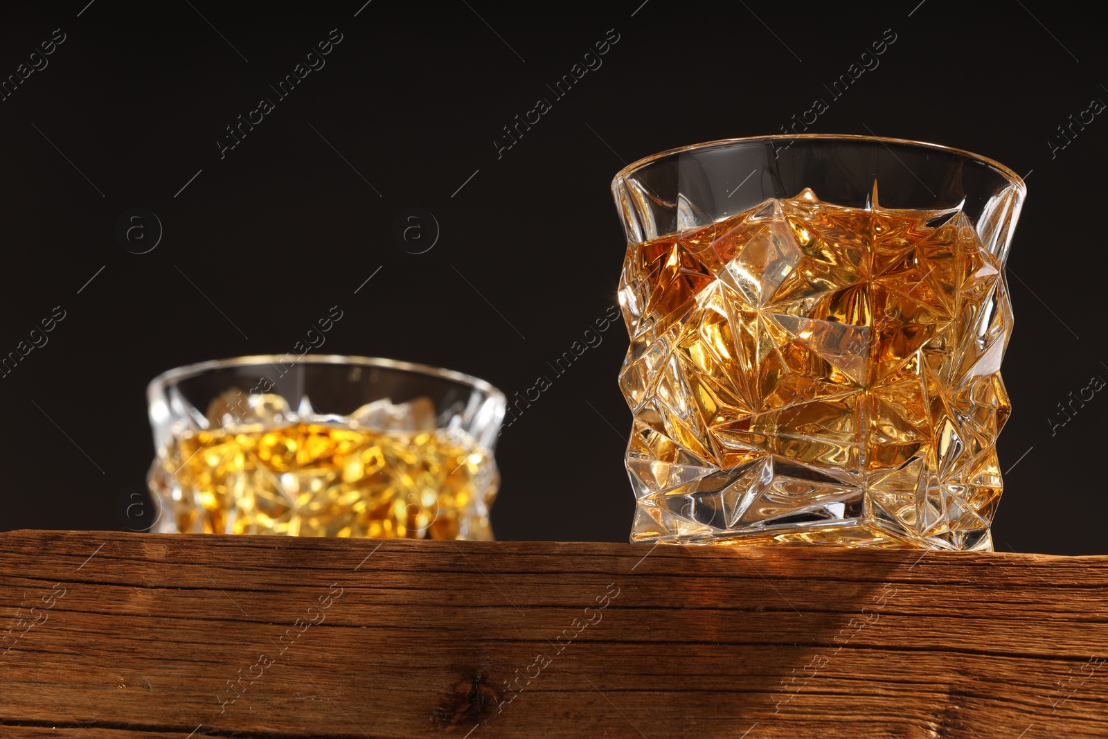 Photo of Whiskey in glasses on wooden table, low angle view