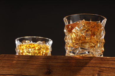 Photo of Whiskey in glasses on wooden table, low angle view