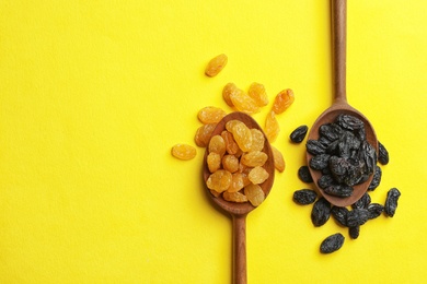 Spoons with raisins and space for text on color background, top view. Dried fruit as healthy snack