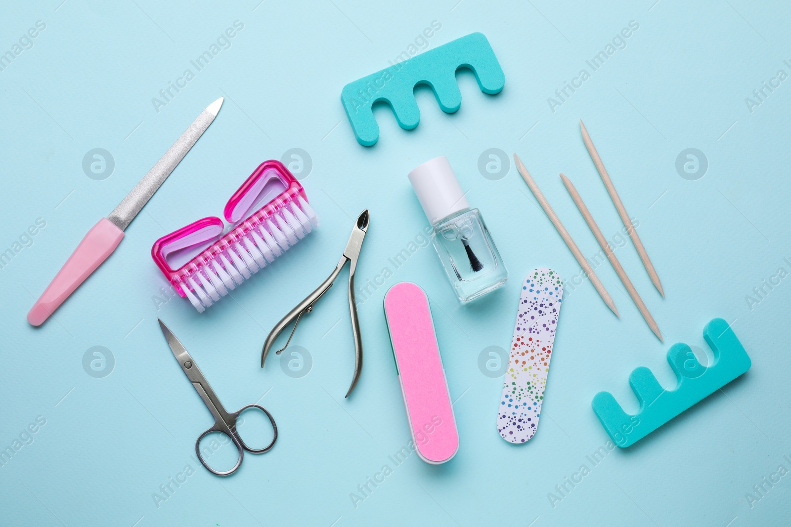 Photo of Set of pedicure tools on light blue background, flat lay