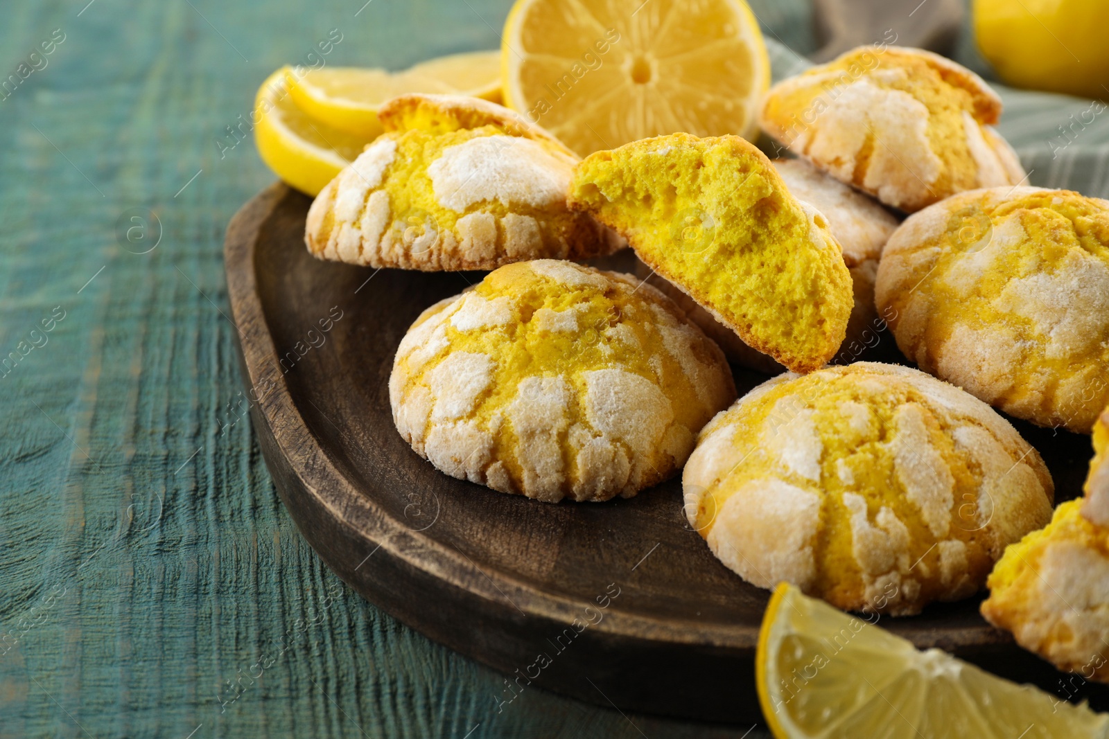 Photo of Board with delicious lemon cookies on light blue wooden table, closeup