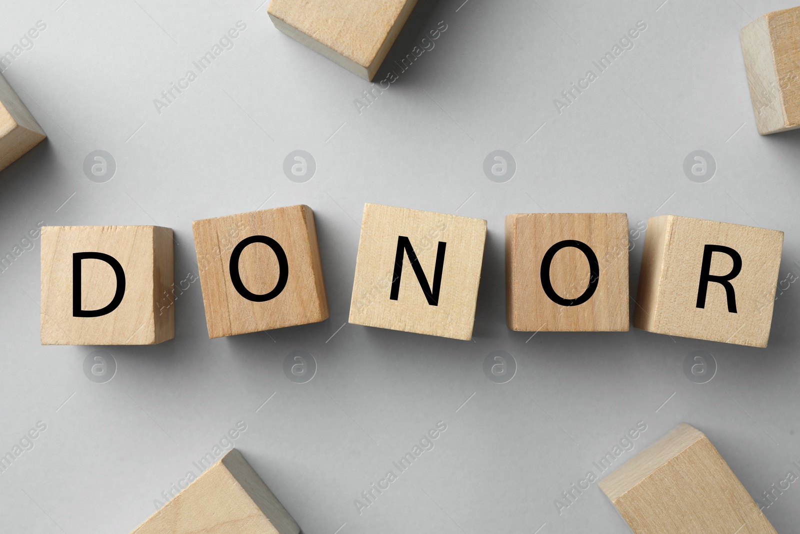Photo of Word Donor made of wooden cubes on light grey table, flat lay