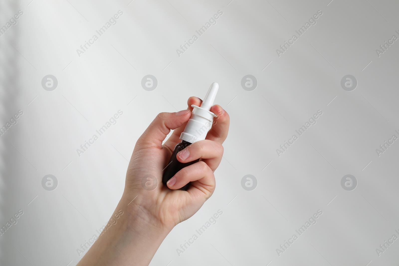 Photo of Woman with nasal spray on white background, closeup