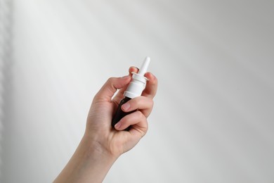 Woman with nasal spray on white background, closeup