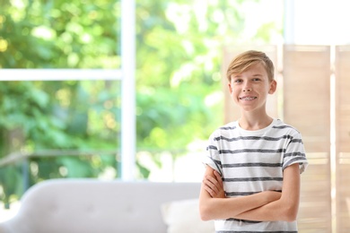 Photo of Portrait of young boy standing near window indoors