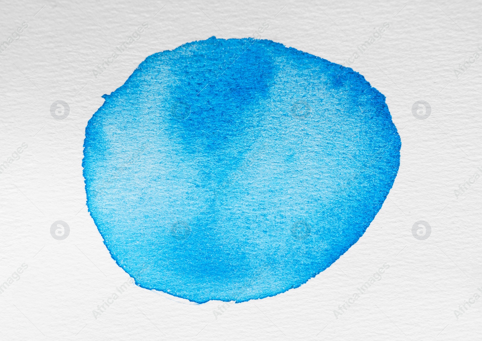 Photo of Blot of light blue watercolor paint on white background, top view
