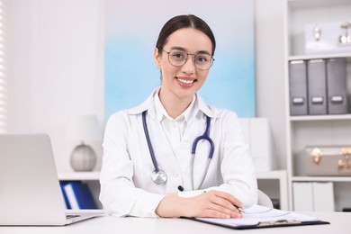 Photo of Medical consultant with stethoscope at table in clinic