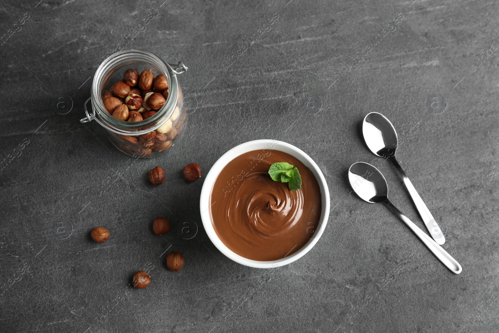 Photo of Flat lay composition with tasty chocolate mousse and hazelnuts on table