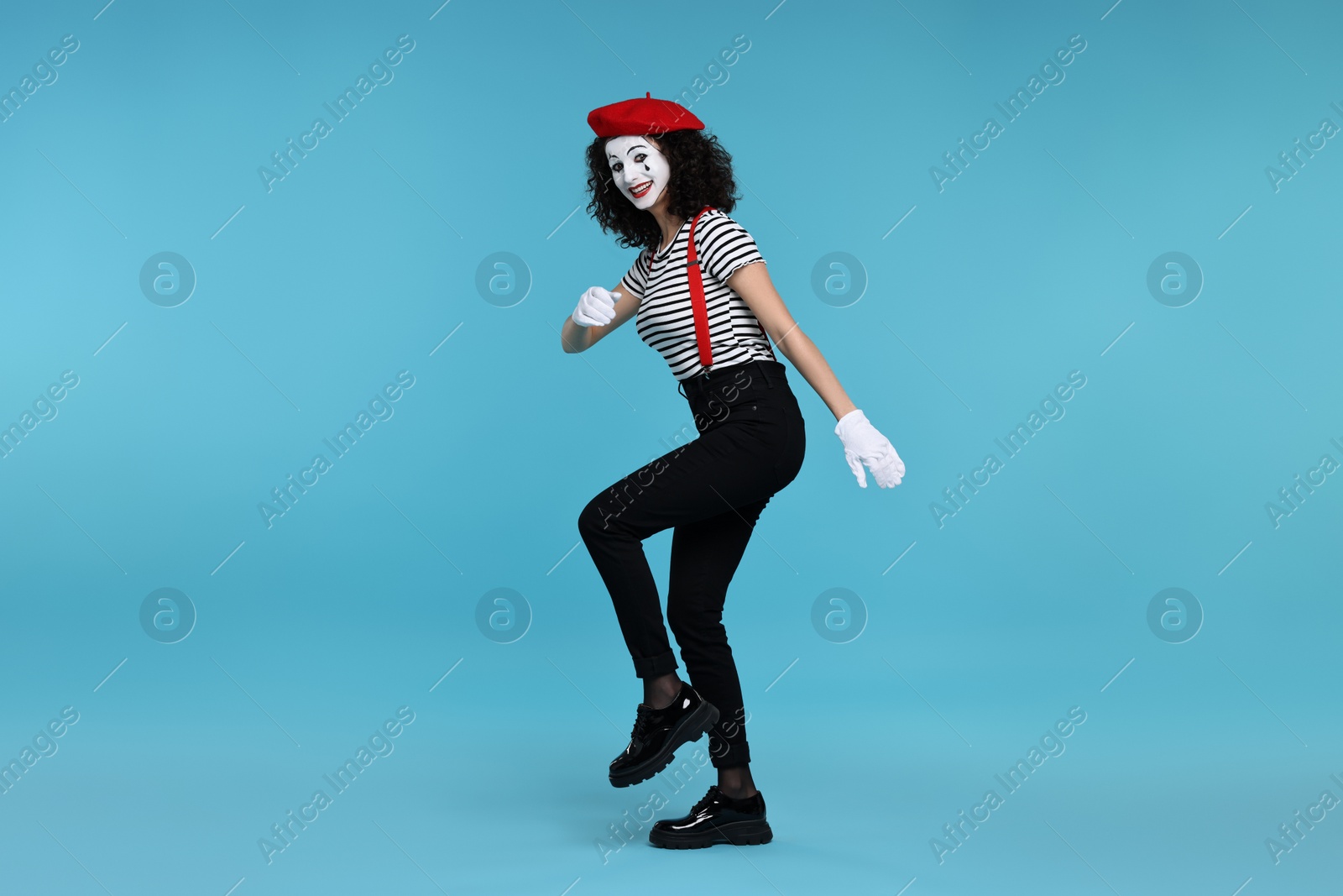 Photo of Funny mime with beret posing on light blue background