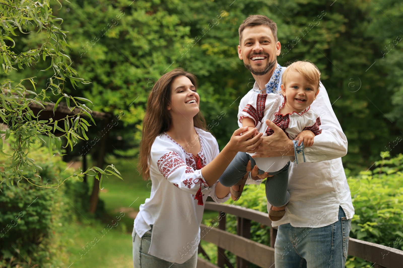 Photo of Happy family in Ukrainian national clothes outdoors