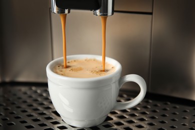 Photo of Espresso machine pouring coffee into cup, closeup