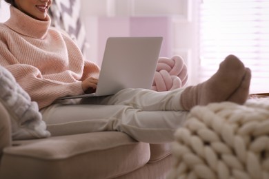 Photo of Woman with laptop relaxing at home, closeup. Cozy atmosphere