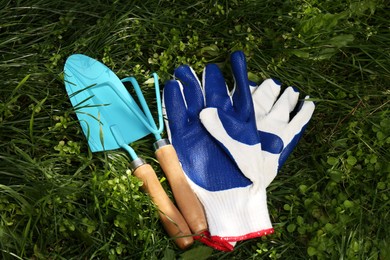 Photo of Gardening gloves and tools on grass outdoors, above view