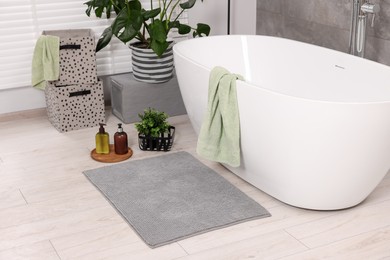 Photo of Stylish bathroom interior with soft bath mat and tub