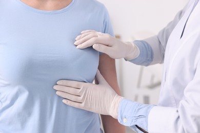 Photo of Mammologist checking woman's breast in hospital, closeup