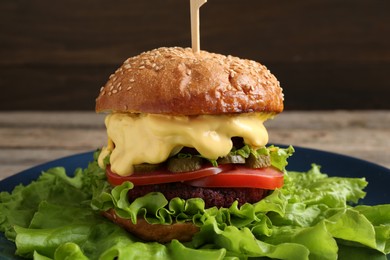 Photo of Delicious vegetarian burger served on table, closeup