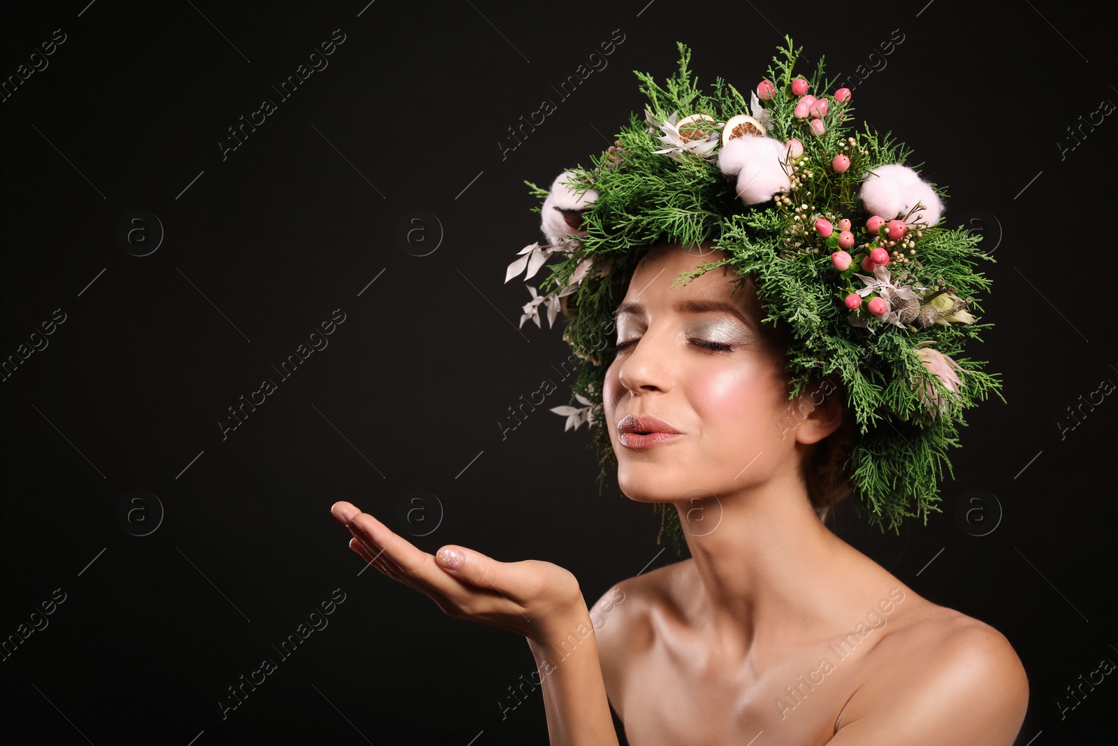 Photo of Young woman wearing wreath on black background