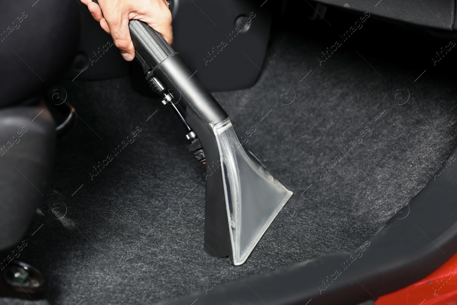 Photo of Man cleaning automobile salon with vacuum cleaner, closeup. Car wash service