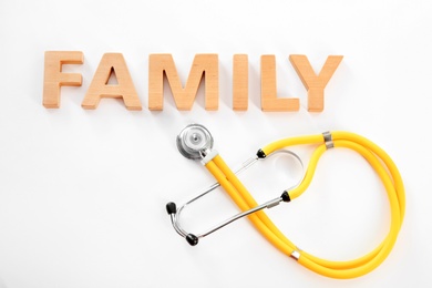 Photo of Word Family made of wooden letters and stethoscope on white background
