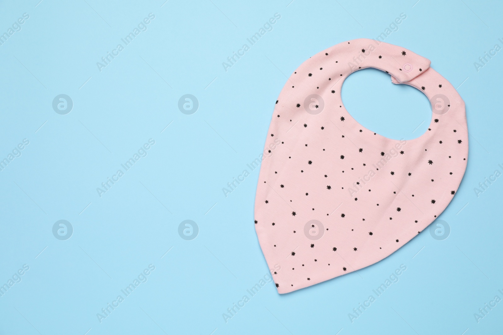 Photo of New baby bib on light blue background, top view. Space for text