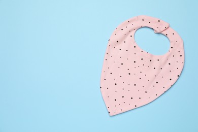 Photo of New baby bib on light blue background, top view. Space for text