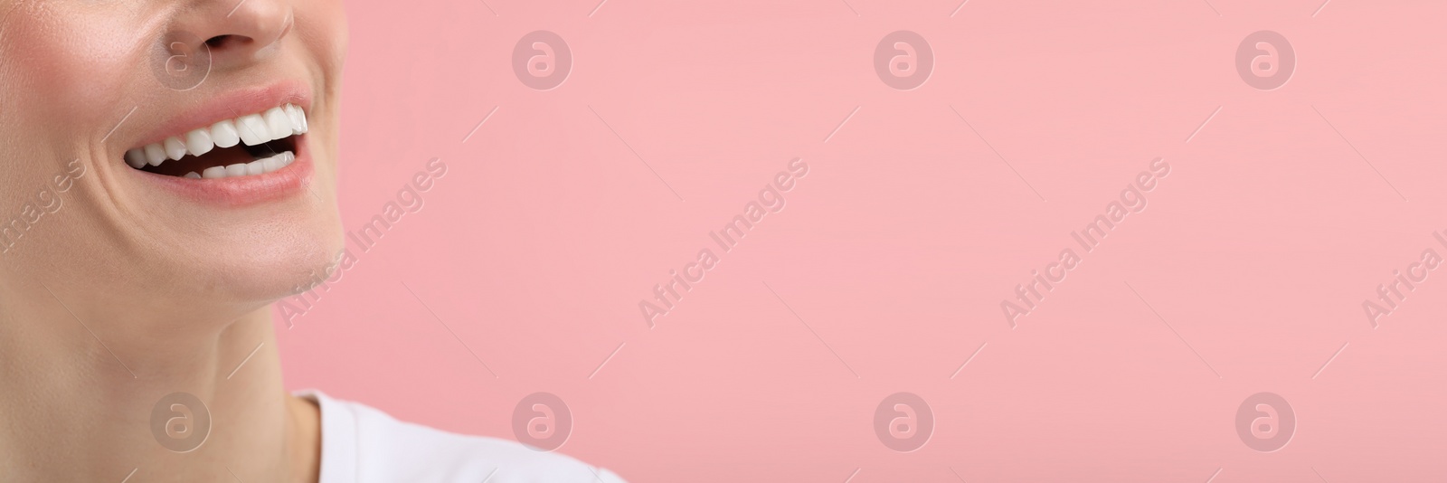 Image of Woman with clean teeth smiling on pink background, closeup. Banner design with space for text